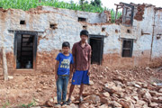 Kinder vor zerstörtem Haus